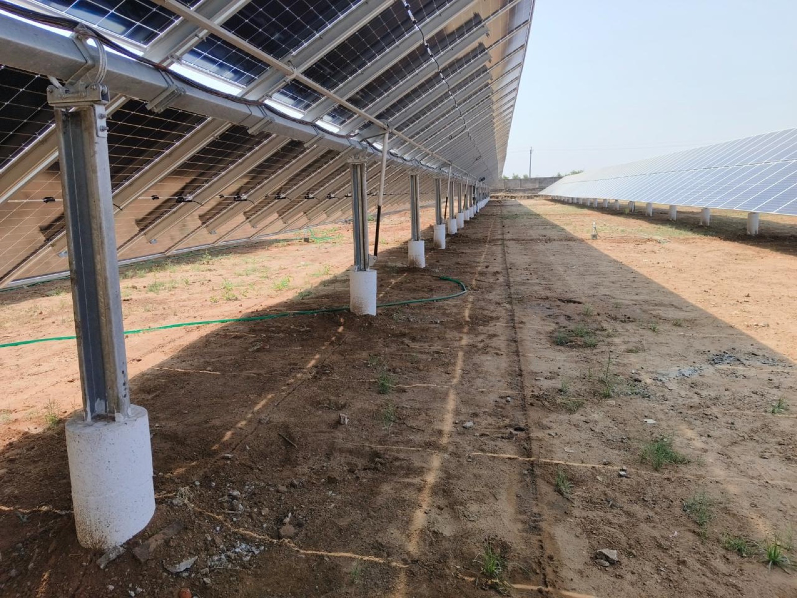 The reverse of a bifacial module table on galvanised posts and concrete pile foundations.