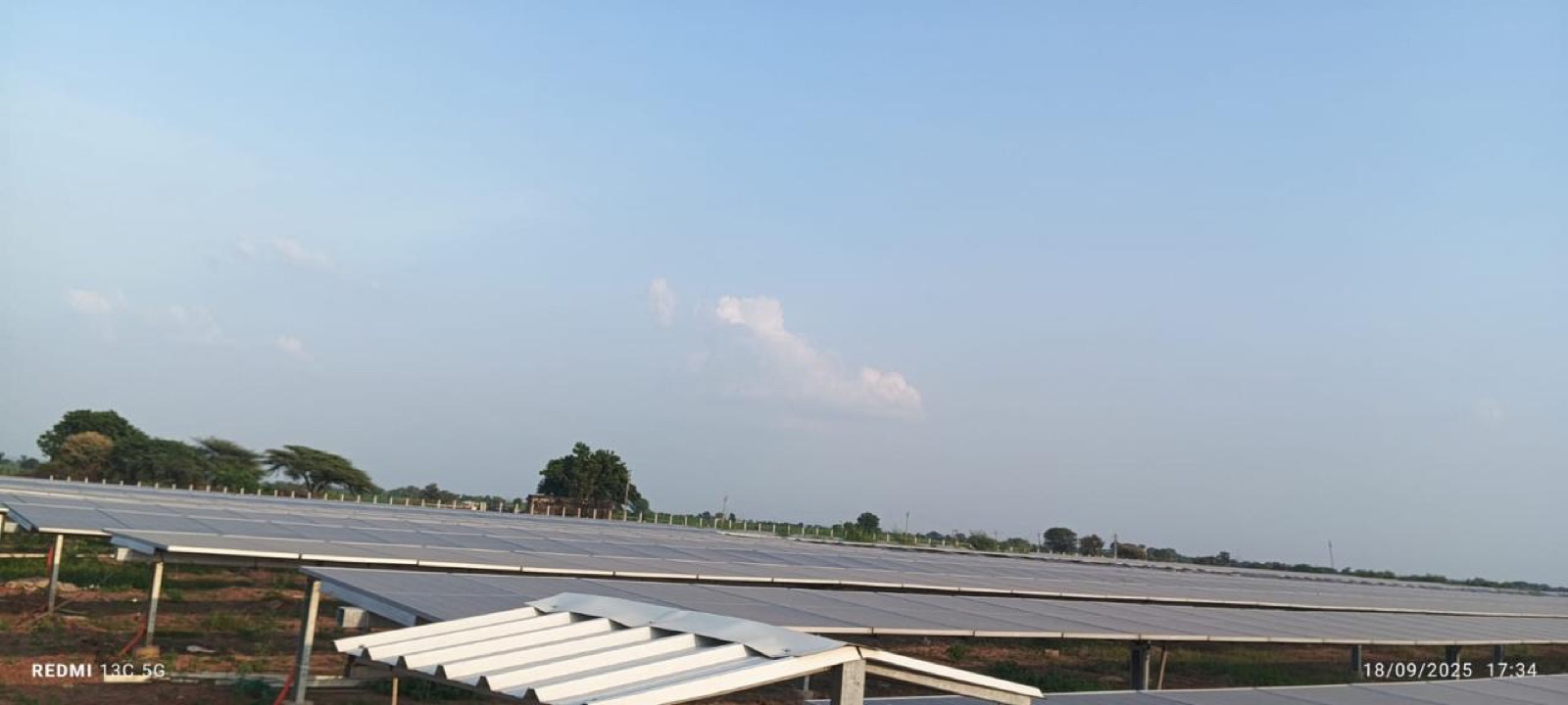 A panorama of bifacial module rows seen from behind across the site.