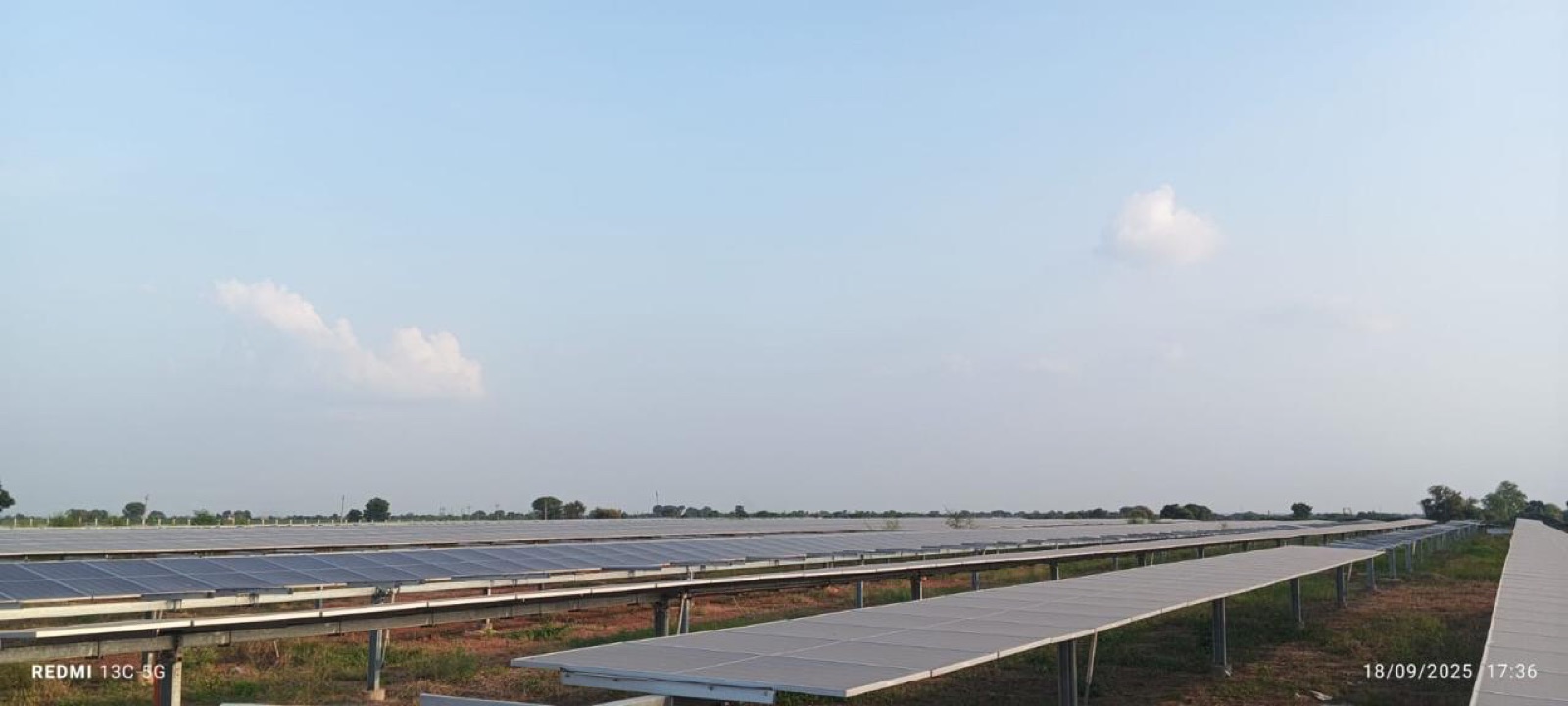 Module rows receding across the full width of the site under a big sky.