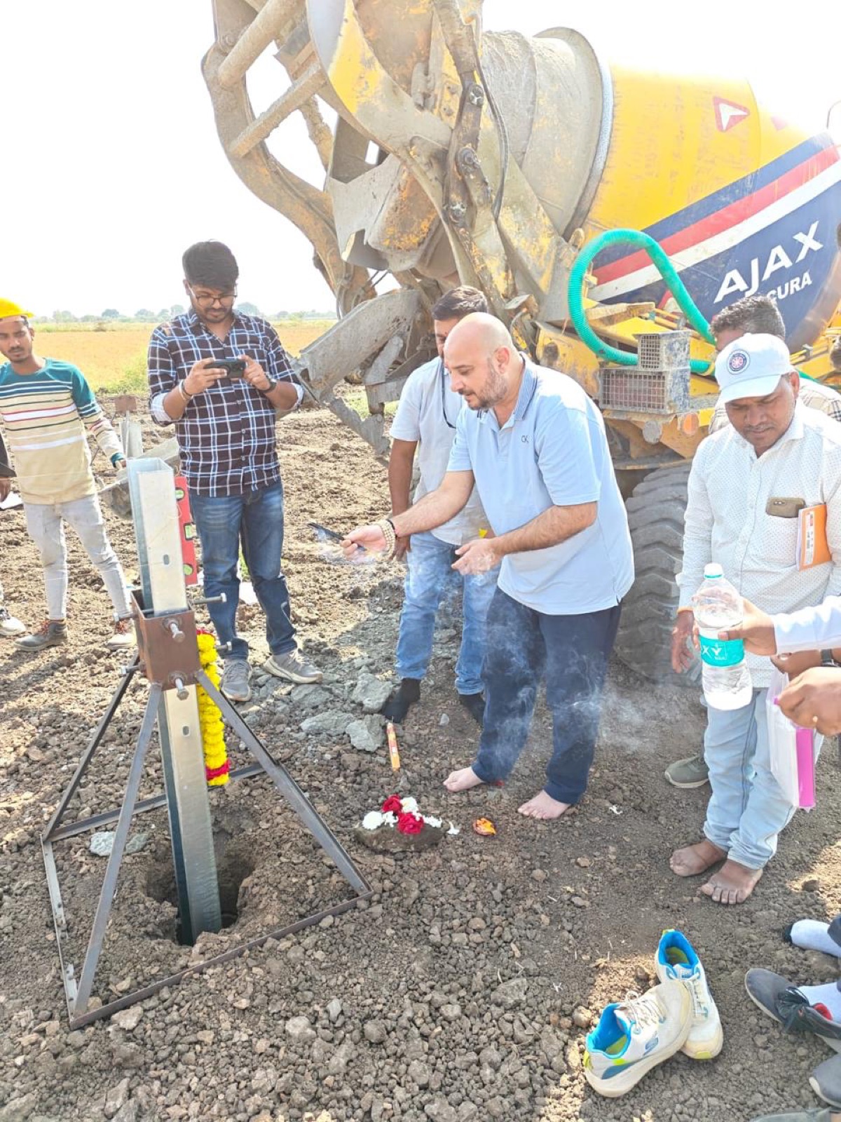 The first concrete pour at a solar site with the team and an AJAX concrete mixer.